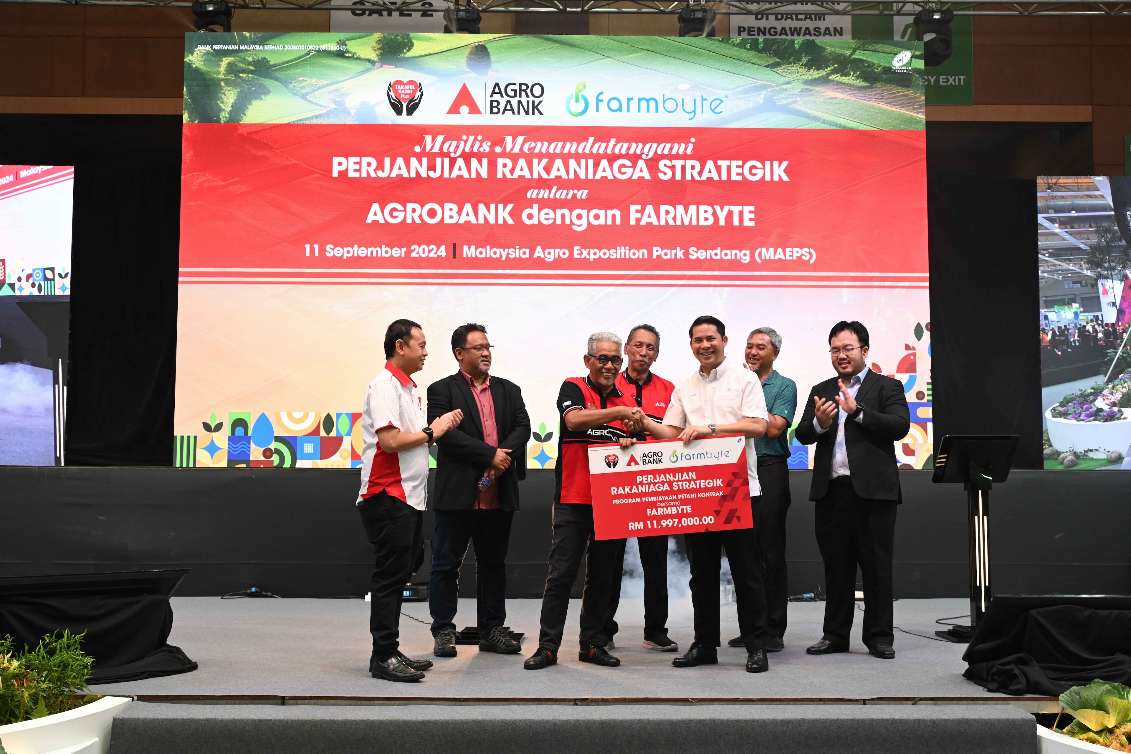CEO FarmByte, Syed Aiman (tiga dari kanan) bersama Presiden dan CEO Agrobank, Tengku Ahmad Badli Shah (tiga dari kiri) memegang plak Program Pembiayaan Petani Kontrak pada majlis menandatangani perjanjian rakan niaga strategik di MAHA 2024, Serdang
